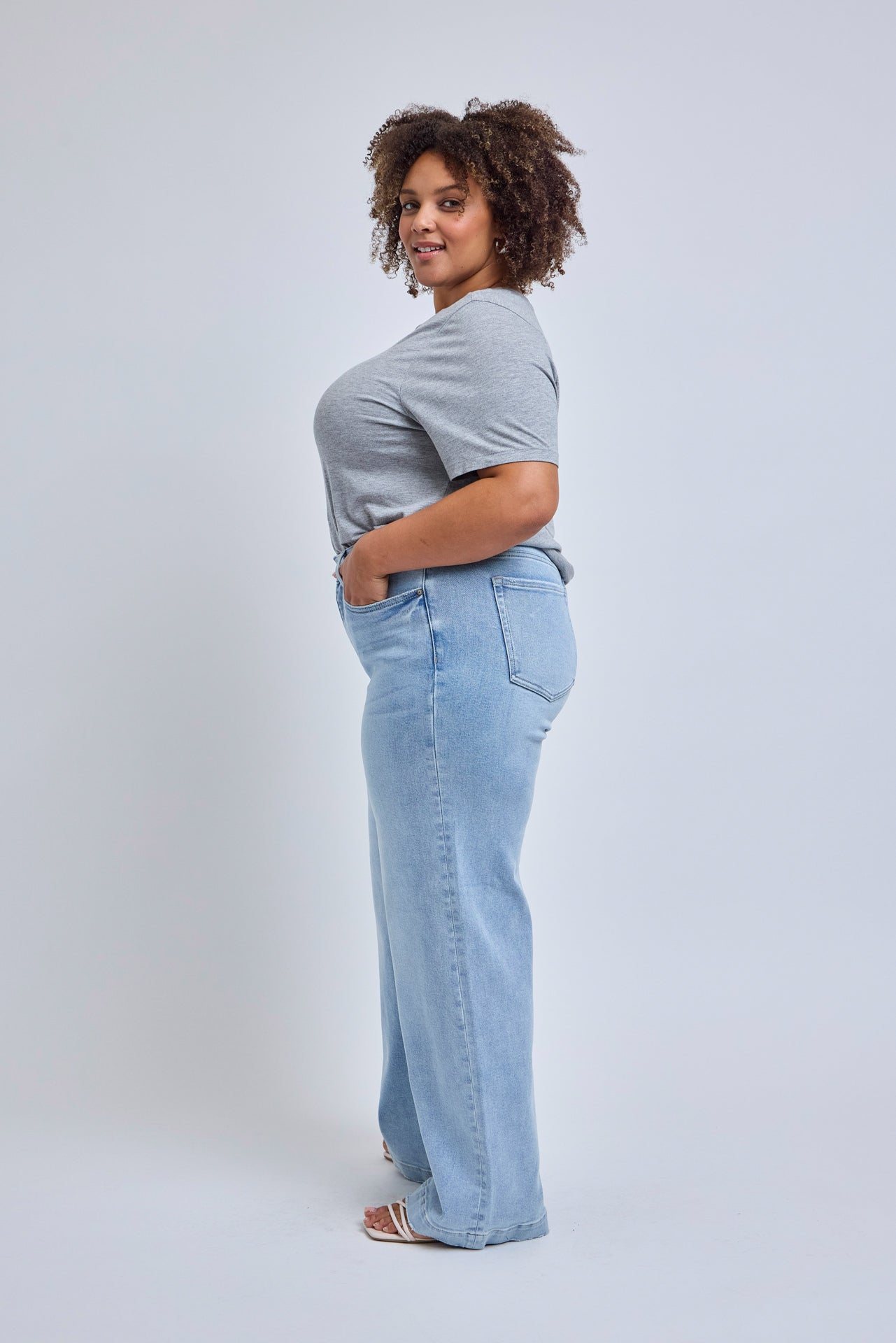 Person wearing a light blue t-shirt and jeans on a white background