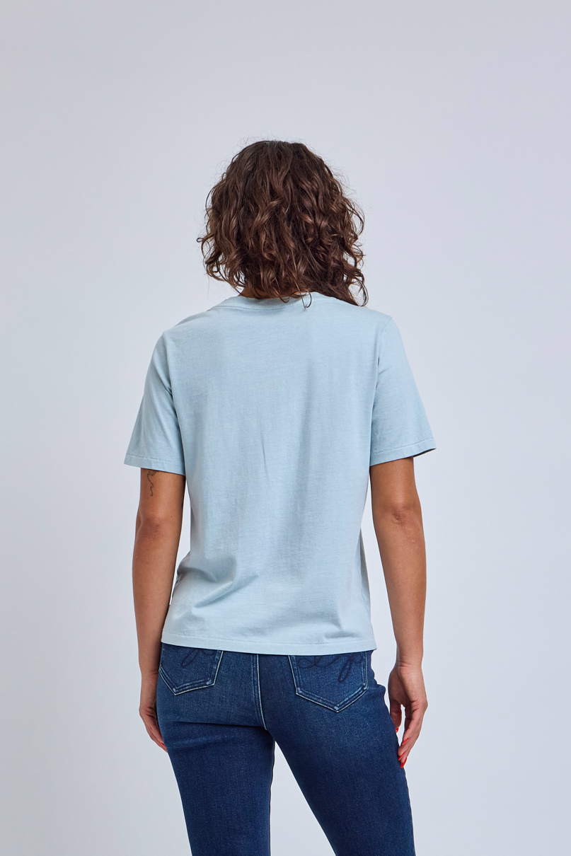 Person wearing a light blue t-shirt and dark blue jeans on a plain background