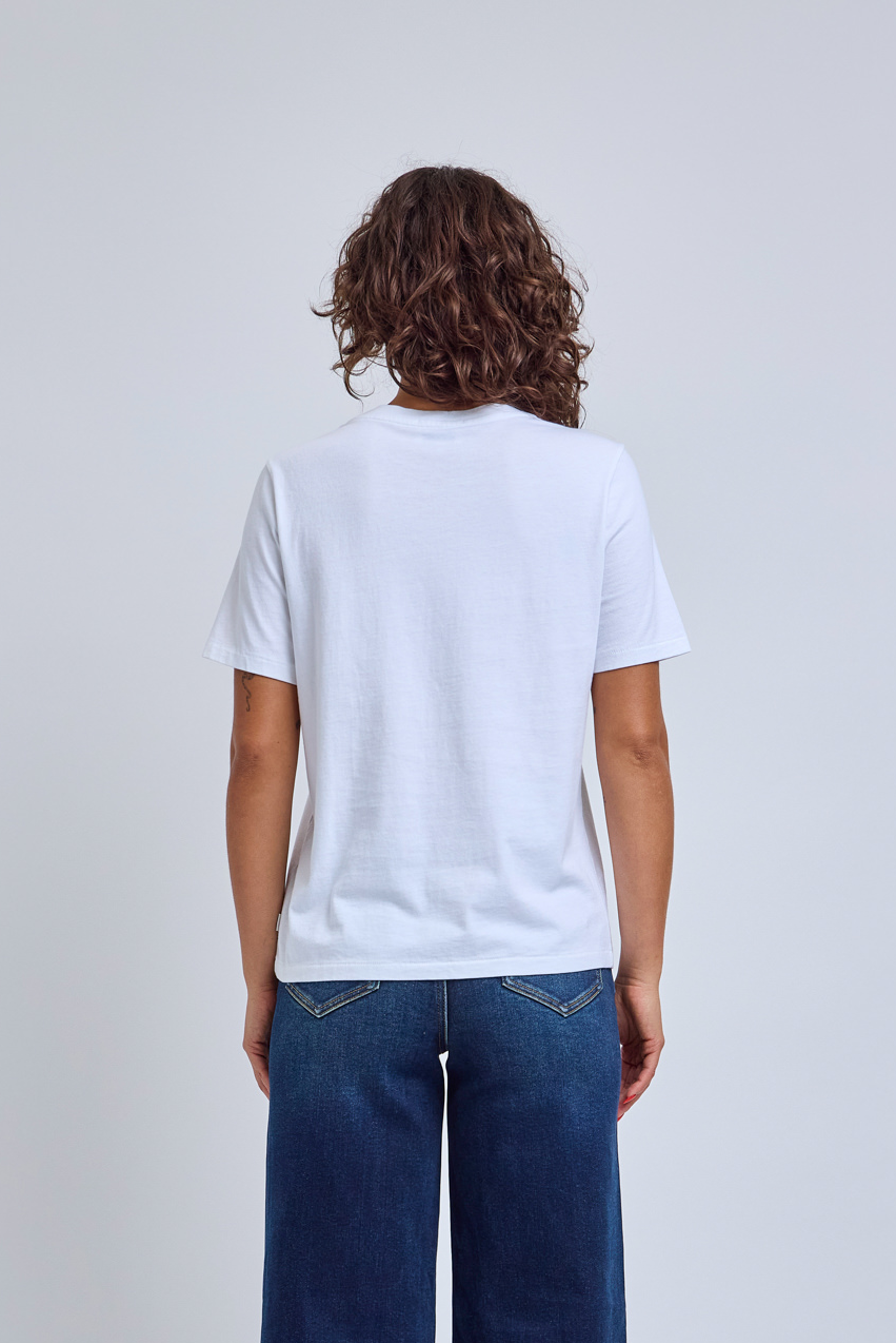 Person wearing a plain white t-shirt and blue jeans on a light gray background