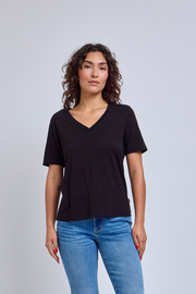 Woman wearing a black t-shirt and blue jeans against a plain background | model-size: 4