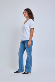 Woman wearing a white t-shirt and blue jeans on a white background