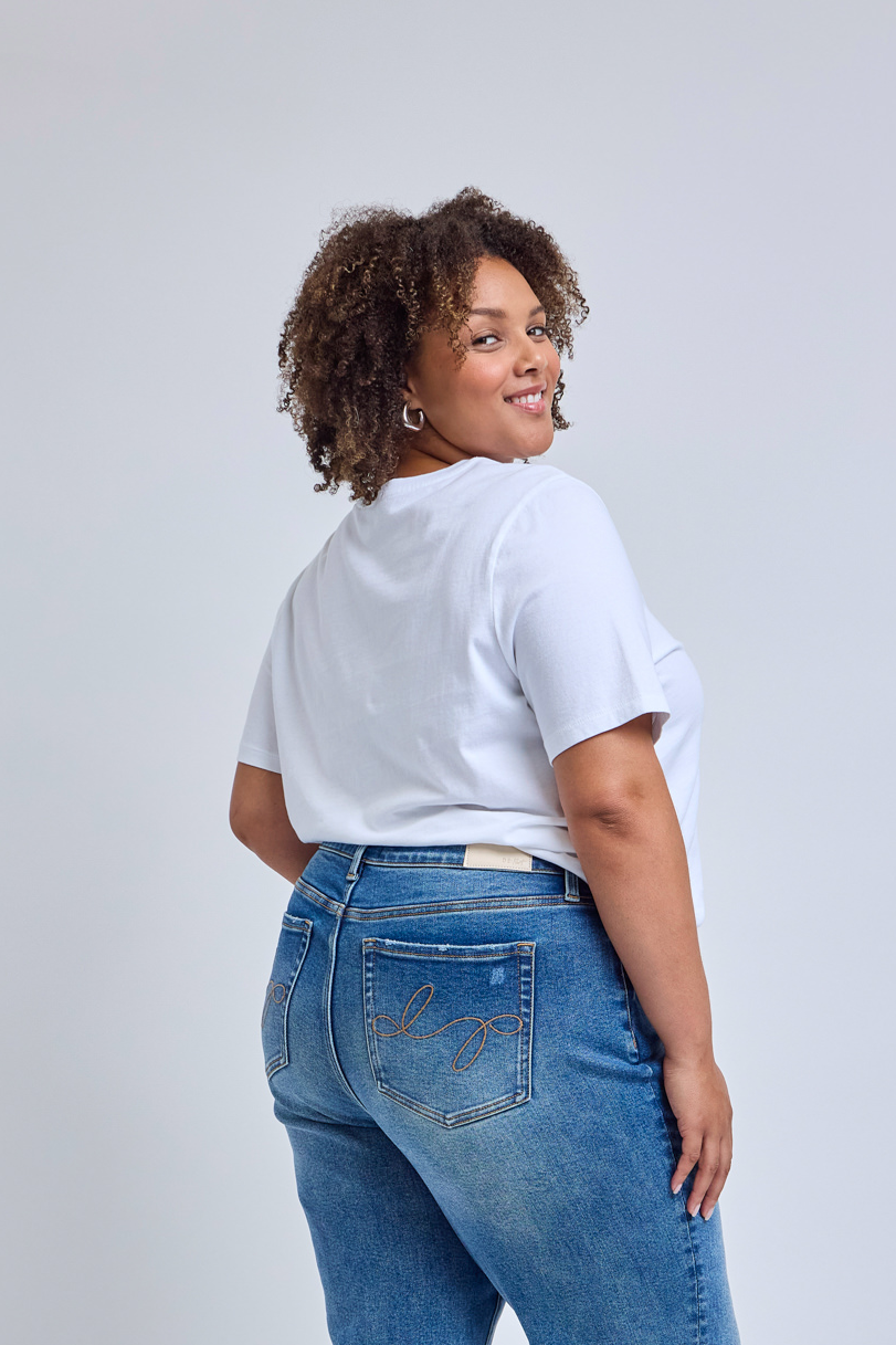 Backside picture of a woman wearing a white t-shirt and jeans.
