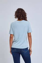 Person wearing a light blue t-shirt and blue jeans on a plain background