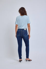 Woman wearing blue jeans and a light blue shirt on a white background