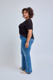 Woman wearing a black t-shirt and blue jeans on a white background