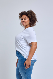 Woman wearing a white t-shirt and blue jeans on a light gray background