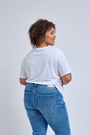 Person wearing a white t-shirt and blue jeans on a plain background