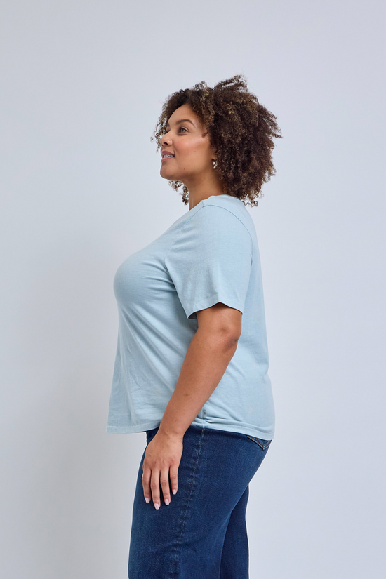 Woman wearing a light blue crew neck t-shirt and jeans
