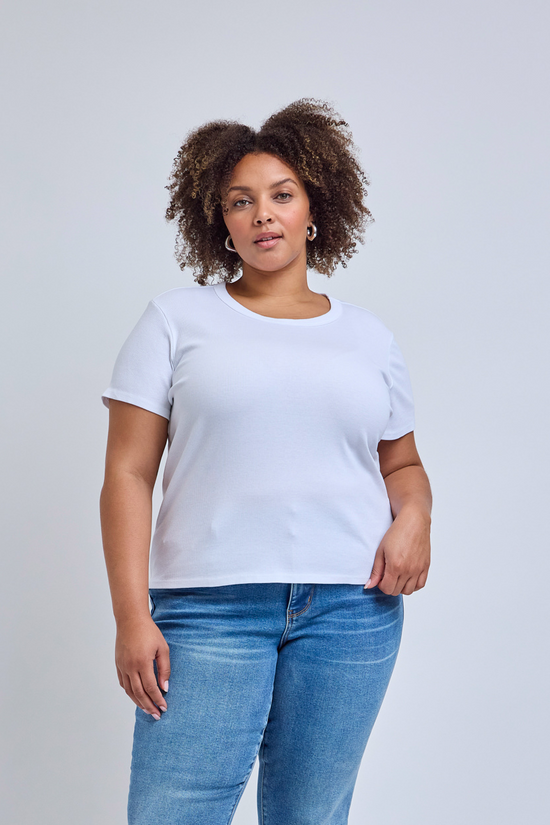 Person wearing a plain white t-shirt and blue jeans on a light gray background | model-size: 16