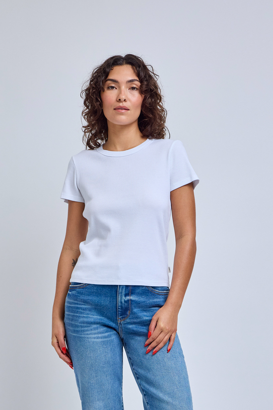 Woman wearing a plain white t-shirt and blue jeans against a light gray background | model-size: 4