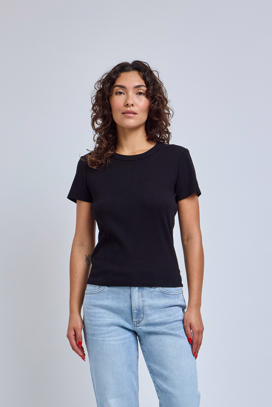 Women wearing a black t-shirt and blue jeans on a plain background