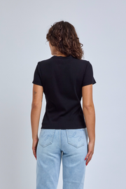 Person wearing a black t-shirt and light blue jeans on a plain background