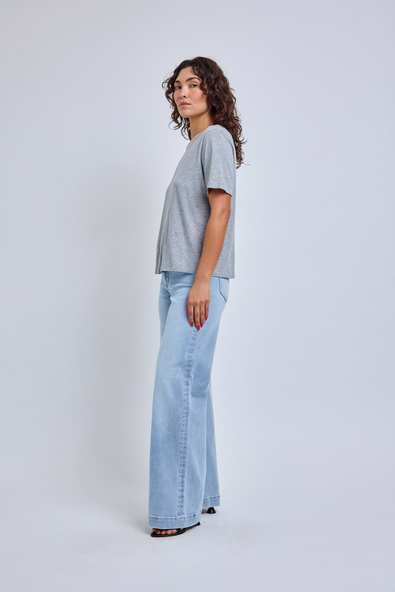 woman wearing a gray t-shirt and light blue wide leg jeans