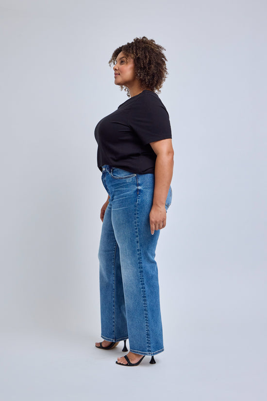 Person wearing a black t-shirt and blue jeans on a white background