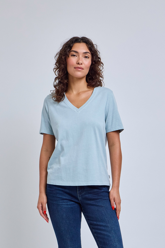 woman wearing a light blue v-neck t-shirt and blue jeans | model-size: 4
