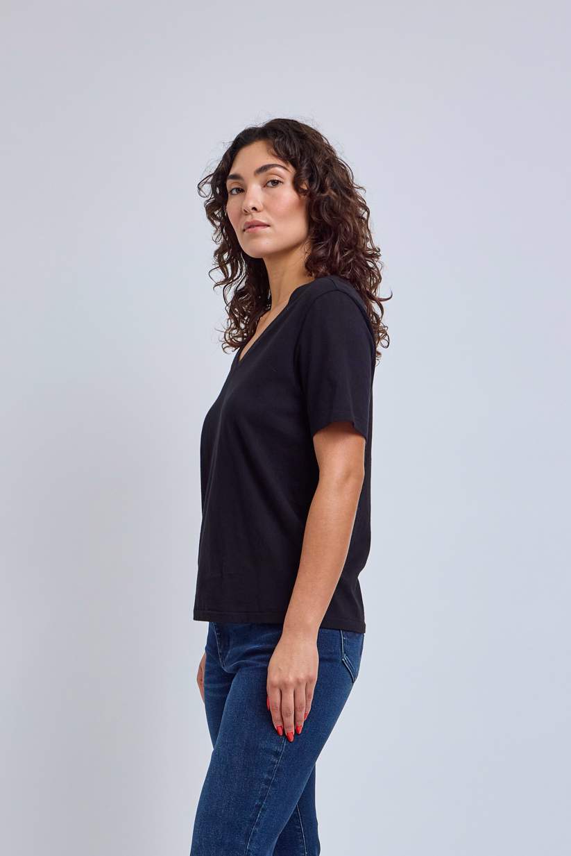 Model wearing a black v-neck t-shirt and blue jeans