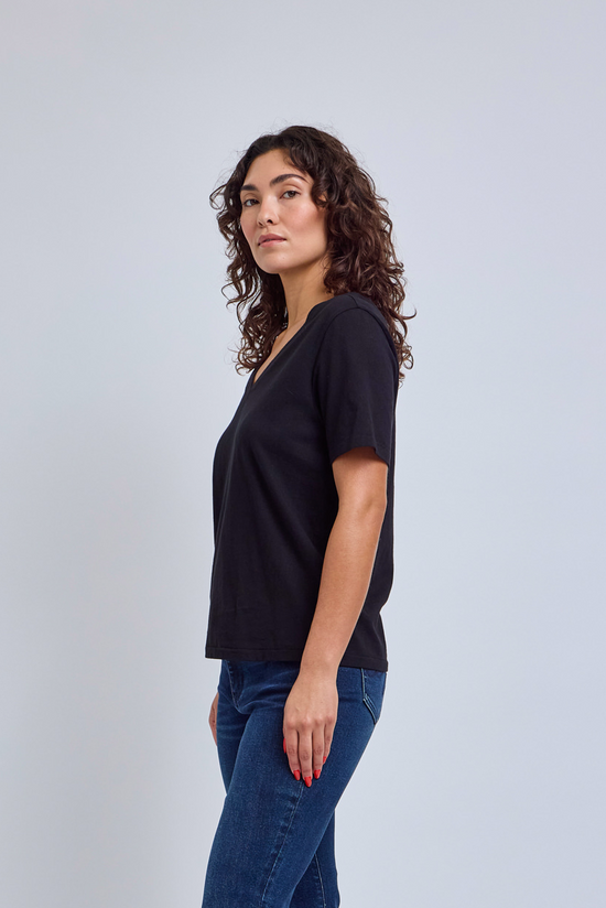 Model wearing a black v-neck t-shirt and blue jeans