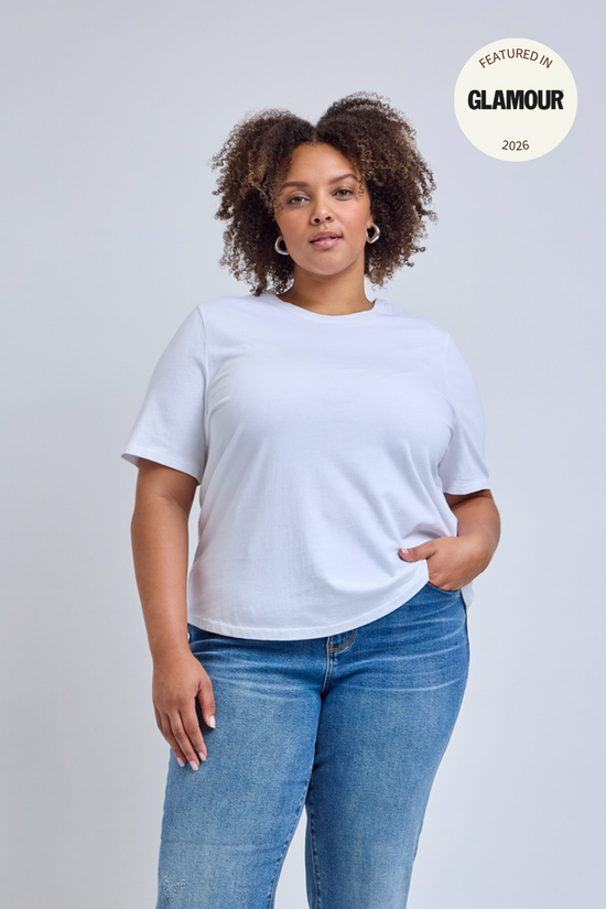 Person wearing a plain white t-shirt and blue jeans on a light gray background.