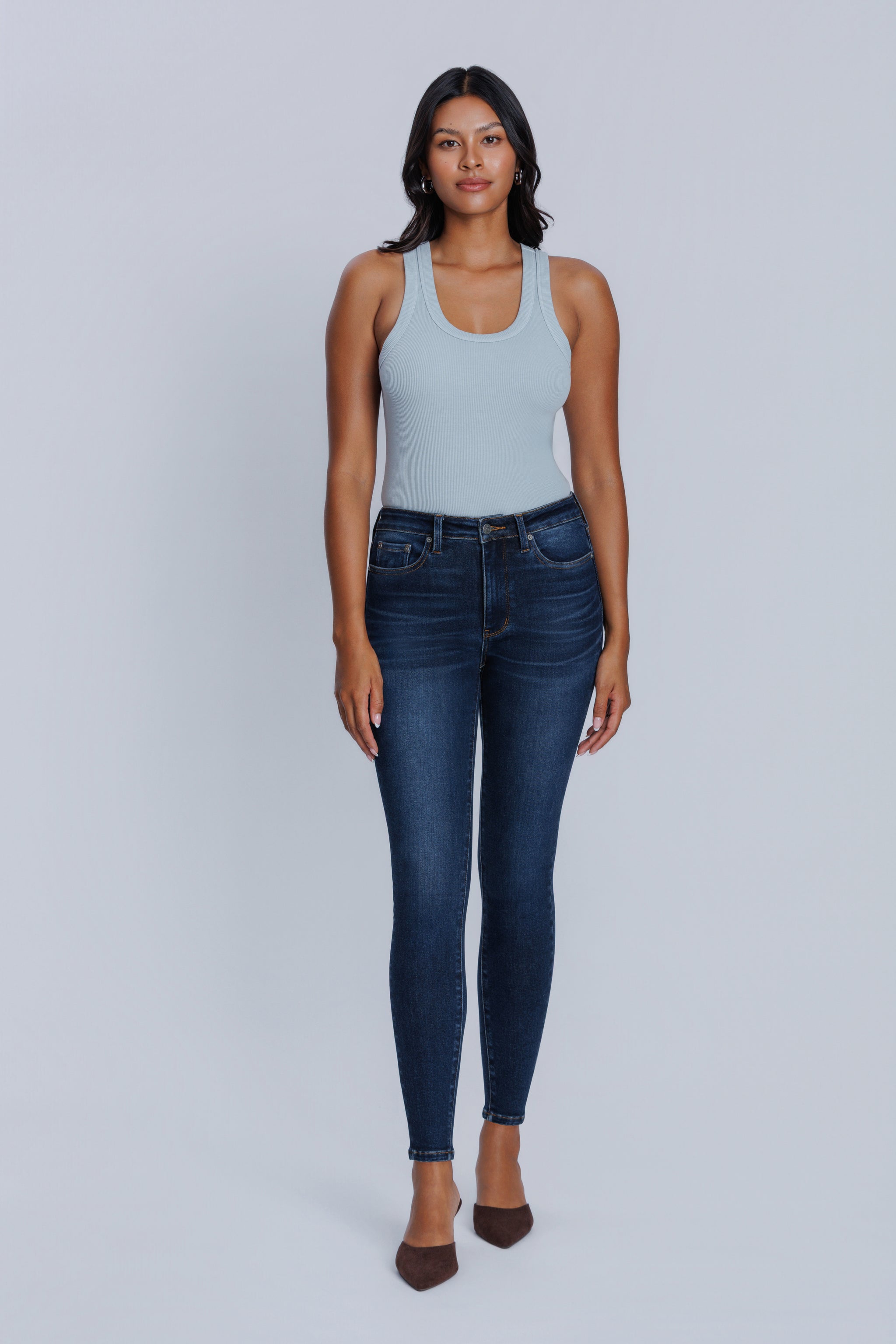 Woman wearing a DePart light blue tank top and dark blue skinny jeans against a light gray background | model-size: 4