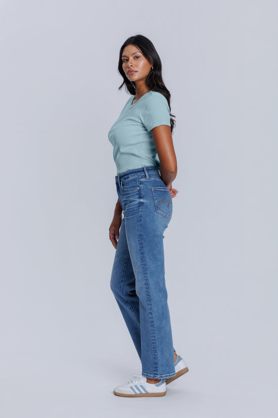 Woman wearing a light blue t-shirt and jeans on a white background