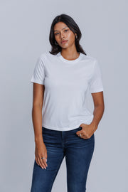 Woman wearing a DePart white t-shirt and dark blue jeans against a light gray background | model-size: 4