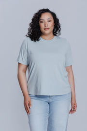 Woman wearing a DePart light blue t-shirt and light blue jeans against a light gray background | model-size: 16