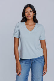 Woman wearing a DePart light blue t-shirt and lblue straight jeans against a light gray background | model-size: 4