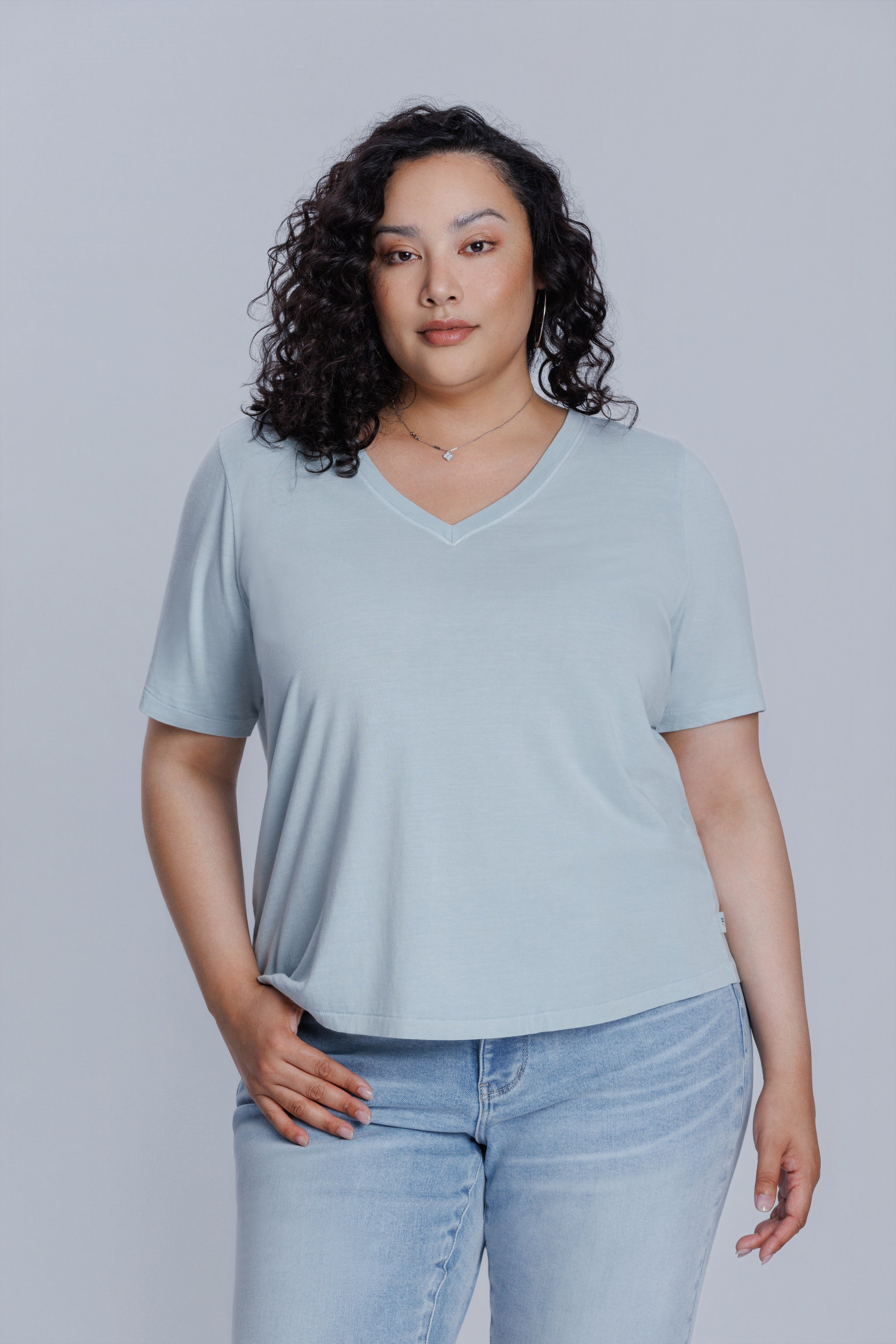 Woman wearing a DePart light blue t-shirt and light blue skinny jeans against a light gray background | model-size: 16