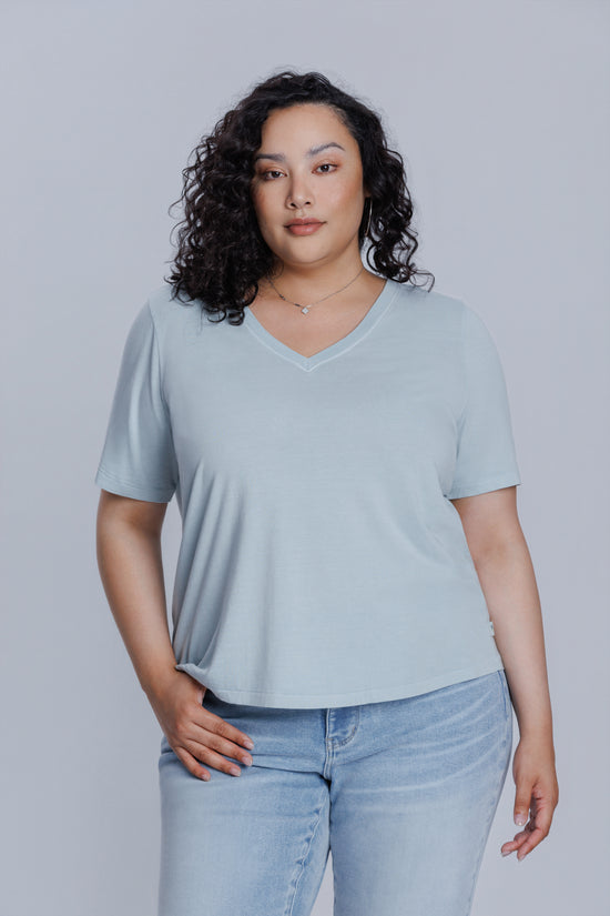 Woman wearing a DePart light blue t-shirt and light blue skinny jeans against a light gray background | model-size: 16