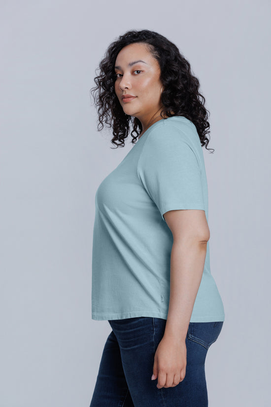 Woman wearing a light blue t-shirt against a plain background