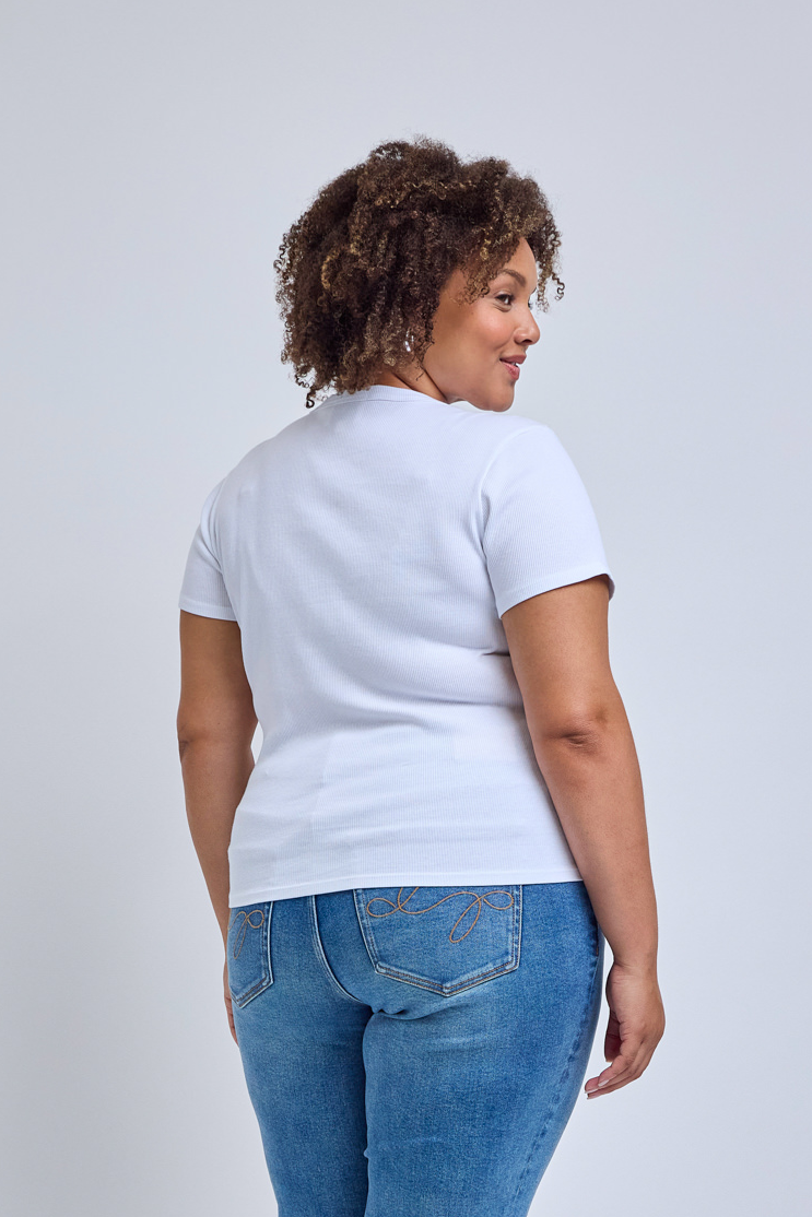 Woman wearing a plain white t-shirt and blue jeans on a light gray background