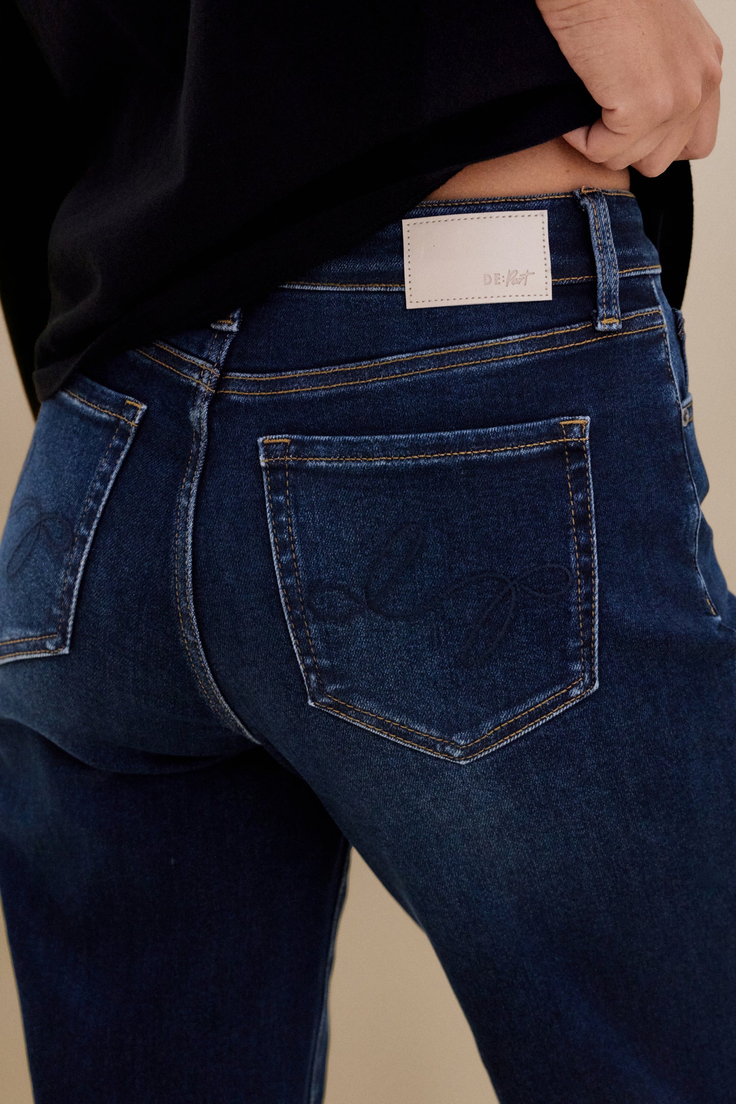 Blue jeans with a visible brand label on a beige background