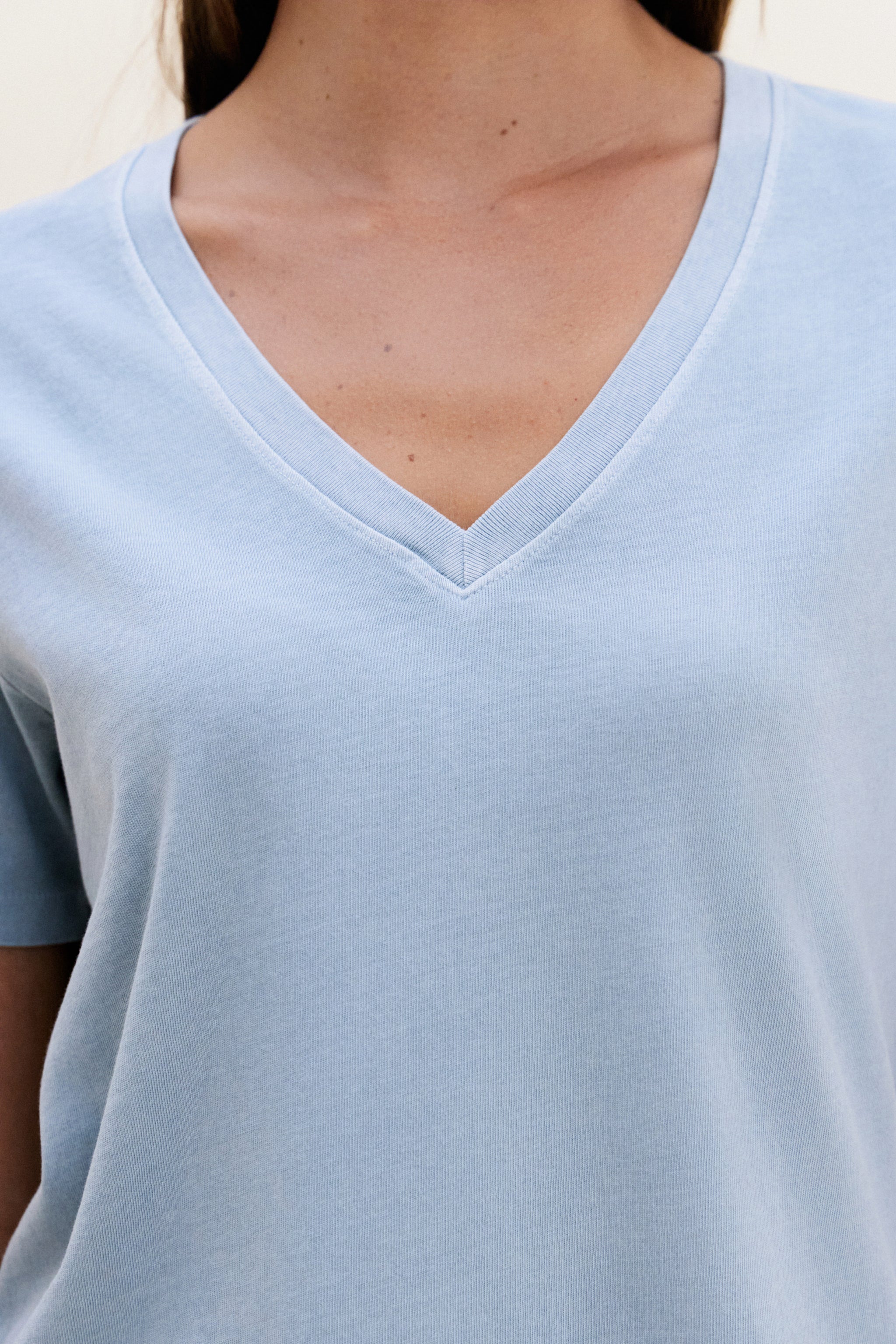 Light blue t-shirt worn by a person, focusing on the neckline.