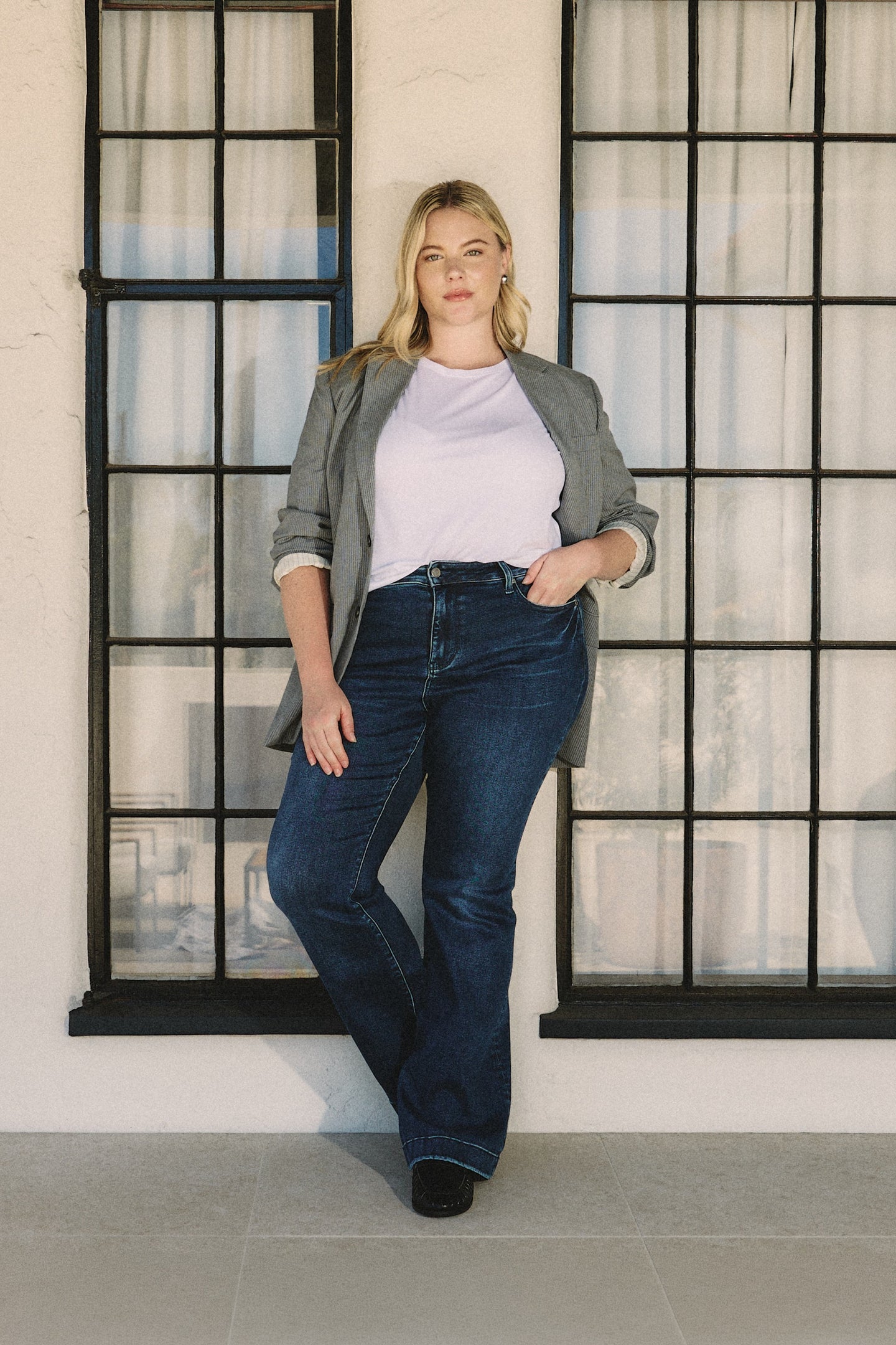 Woman standing in front of a window with a neutral background