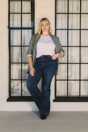 Woman standing in front of a window with a neutral background | model-size: 16