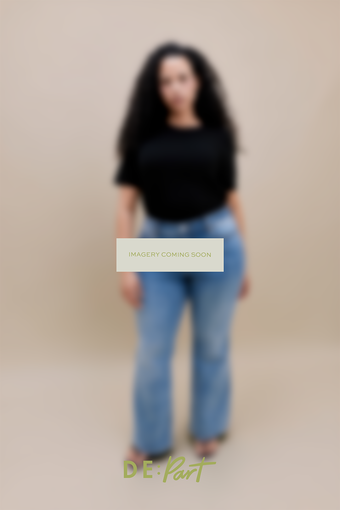 A model wearing a black short-sleeve top and light blue jeans, standing against a plain beige studio background. The image is heavily blurred, and a central overlay reads 'IMAGERY COMING SOON'.