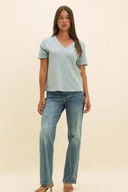 Video of a woman wearing a blue v-neck t-shirt and straight leg blue jeans.