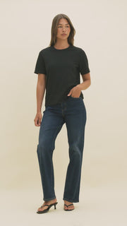 Video of a woman wearing dark denim and a black t-shirt