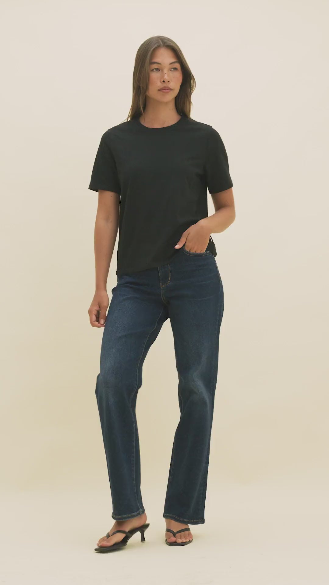 Video of a woman wearing dark denim and a black t-shirt