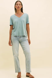 Video of a woman wearing a light blue v-neck t-shirt and light blue straight leg jeans.