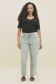 Video of a woman wearing a black v-neck t-shirt and light blue straight jeans.