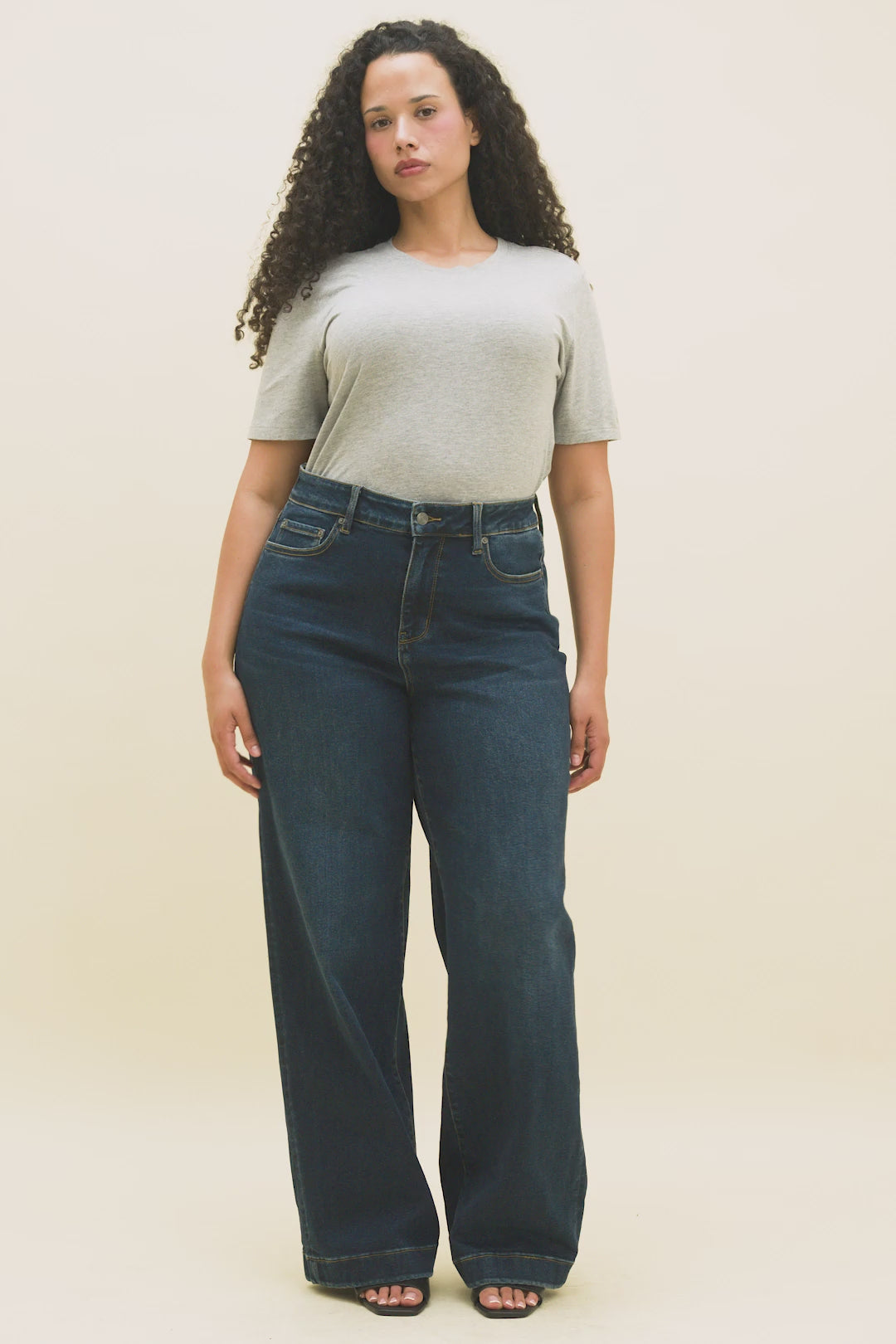 Video of a woman wearing a heather grey t-shirt and dark blue wide leg jeans.