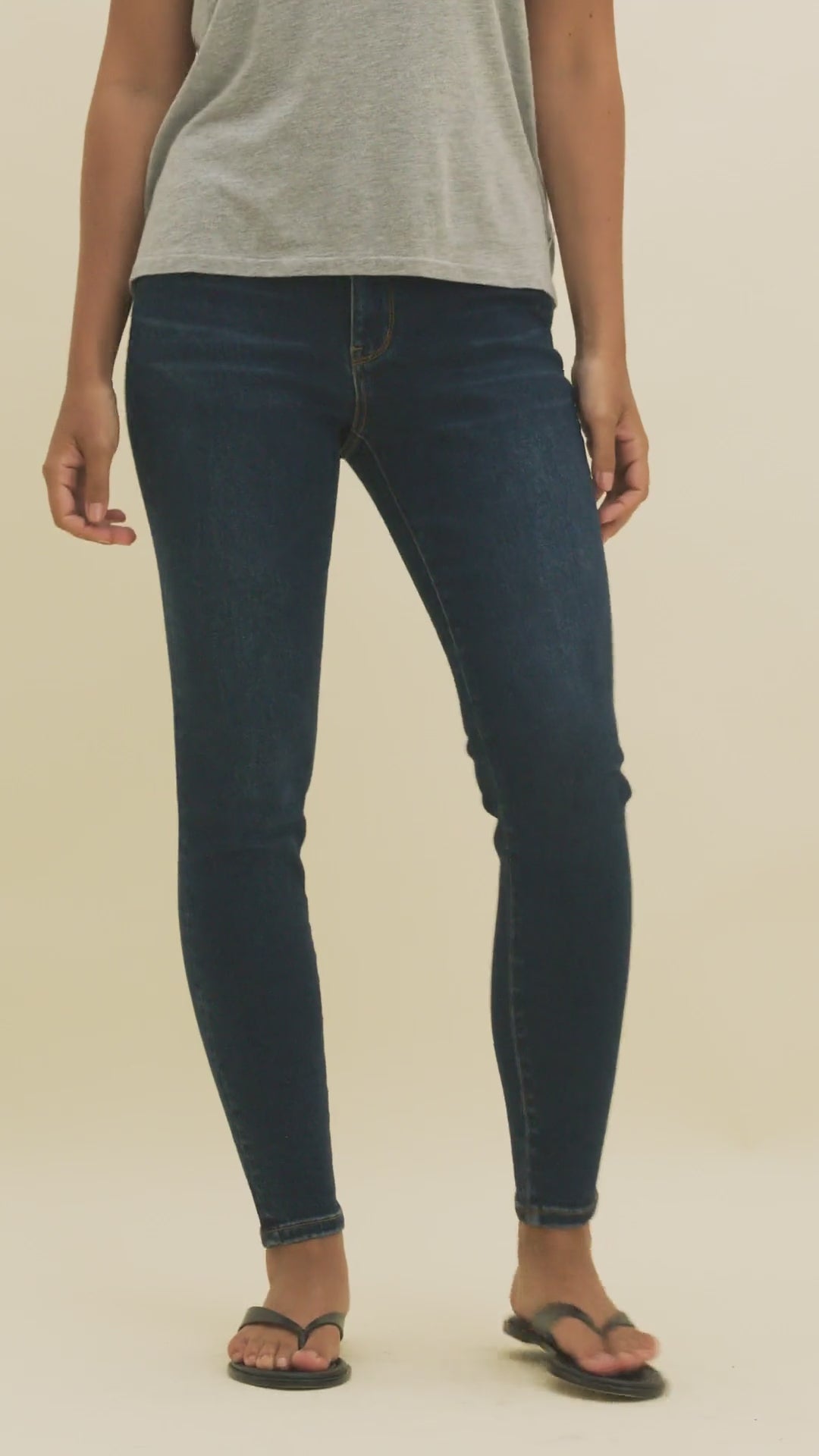 Video of a woman wearing dark skinny jeans and a gray t-shirt