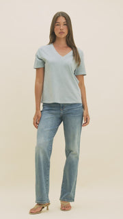 Video of a woman in medium wash jeans and a light blue v-neck t-shirt