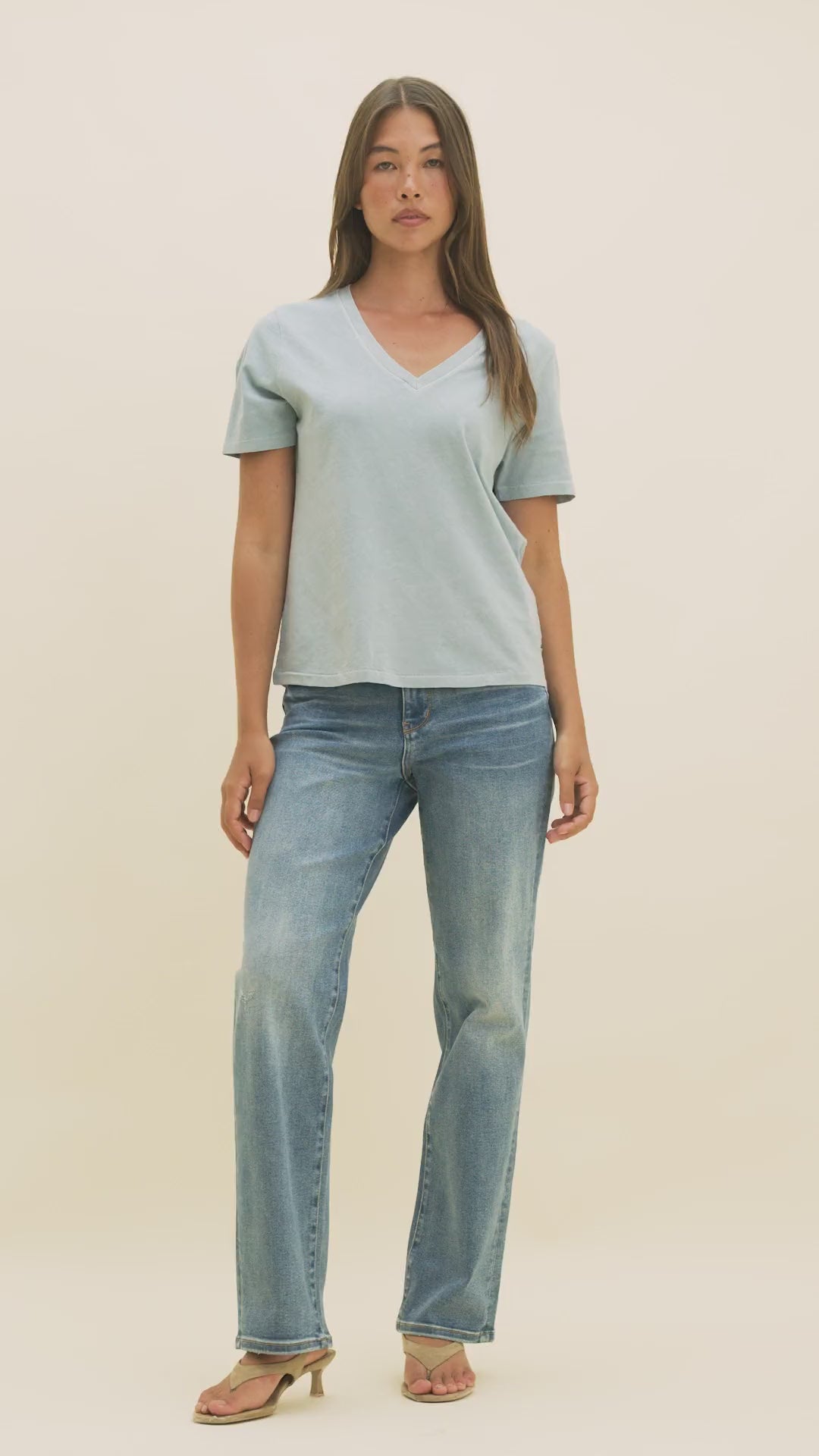 Video of a woman in medium wash jeans and a light blue v-neck t-shirt